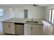 View of bright kitchen with granite countertops, stainless steel dishwasher, and neutral tile floors at 9172 Ravel St, Port Charlotte, FL 33981