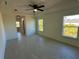 Spacious main bedroom with tray ceiling, a ceiling fan, tile floors, natural light and an ensuite bathroom at 9172 Ravel St, Port Charlotte, FL 33981