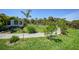 Landscaped backyard featuring a grass area, plants, and stone walkway leading to a seating area at 9350 Prospect Ave, Englewood, FL 34224