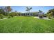 Wide backyard with a lush lawn, mature trees, and a charming patio set for outdoor relaxation at 9350 Prospect Ave, Englewood, FL 34224