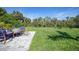 A spacious, green backyard featuring a paved stone patio with comfortable outdoor furniture at 9350 Prospect Ave, Englewood, FL 34224