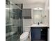 Bathroom featuring a blue vanity with modern countertop and fixtures and a tiled shower at 9350 Prospect Ave, Englewood, FL 34224