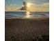 Picturesque beach with a sunset casting warm light on the sand and tranquil waves at 9350 Prospect Ave, Englewood, FL 34224