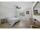 Bright bedroom with a ceiling fan, white walls, light-colored tile floors, a window with views, and white bedroom furniture at 9350 Prospect Ave, Englewood, FL 34224