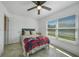 Bedroom with a ceiling fan, window, and tile flooring with a bed with a colorful blanket at 9350 Prospect Ave, Englewood, FL 34224