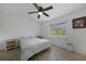 Bright bedroom with a ceiling fan, white walls, light-colored tile floors, and a window with views at 9350 Prospect Ave, Englewood, FL 34224