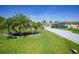 Beautiful home exterior showcasing a manicured lawn, swaying palm trees, and a pristine paved driveway at 9350 Prospect Ave, Englewood, FL 34224