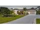 A charming home exterior with a well-kept lawn, palm trees, and a paved driveway at 9350 Prospect Ave, Englewood, FL 34224