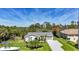 An elevated view of a nicely landscaped one-story home with a lengthy paved driveway at 9350 Prospect Ave, Englewood, FL 34224