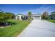 Charming home with well-manicured lawn, palm trees, and a long driveway leading to the garage at 9350 Prospect Ave, Englewood, FL 34224