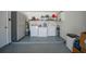 Garage area featuring a washer, dryer, storage cabinet, and shelving for organized utility at 9350 Prospect Ave, Englewood, FL 34224