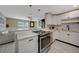 Stylish kitchen featuring white cabinets, marble countertops, and stainless steel appliances, open layout at 9350 Prospect Ave, Englewood, FL 34224