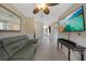 Comfortable living room with a flat-screen tv, neutral walls, a leather couch, and light tile floors at 9350 Prospect Ave, Englewood, FL 34224