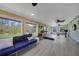 Bright sunroom with wood accents, ceiling fans, exercise equipment, comfortable wicker couch, and lots of natural light at 9350 Prospect Ave, Englewood, FL 34224