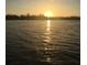 Scenic sunset view over calm water with silhouetted trees on the horizon, reflecting sunlight at 9350 Prospect Ave, Englewood, FL 34224