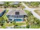Aerial view of the home highlighting the screened-in pool, solar panels and landscaping at 10082 Army Cir, Port Charlotte, FL 33981