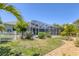 A backyard with a screened-in lanai and a white picket fence, surrounded by grass and landscaped areas at 10082 Army Cir, Port Charlotte, FL 33981