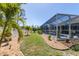 The backyard offers a screened-in lanai, manicured lawn, and gravel landscaping at 10082 Army Cir, Port Charlotte, FL 33981