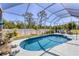 Private screened-in pool area featuring lush landscaping and comfortable seating at 10082 Army Cir, Port Charlotte, FL 33981