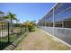 View of the backyard featuring a screen-enclosed patio and black metal fence at 10183 Winding River Rd, Punta Gorda, FL 33950