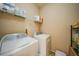 Convenient laundry room with white appliances and storage shelves at 10183 Winding River Rd, Punta Gorda, FL 33950