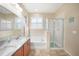 Elegant bathroom featuring double vanity, large soaking tub, glass-enclosed shower, and ample lighting at 10183 Winding River Rd, Punta Gorda, FL 33950