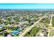 An aerial view of a neighborhood with houses surrounded by lush greenery with the ocean visible in the distance at 10299 Willmington Blvd, Englewood, FL 34224