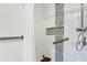 Accessible bathroom with white tile walls, a shower seat, a grab bar, and a rainfall shower head at 10299 Willmington Blvd, Englewood, FL 34224