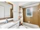 Bathroom with granite vanity, framed mirror, and tiled tub with shower at 10299 Willmington Blvd, Englewood, FL 34224