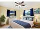 Inviting bedroom features natural light, white furniture and blue accents at 10299 Willmington Blvd, Englewood, FL 34224