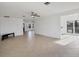 Open-concept living area with tiled floors, a black console, and a ceiling fan at 10299 Willmington Blvd, Englewood, FL 34224