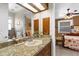 Bathroom with granite countertops, wood cabinets, and views into the bedroom area at 103 Mecca St, Port Charlotte, FL 33954