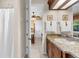 Bathroom featuring granite countertops, wooden cabinetry, and a view into the adjoining bedroom at 103 Mecca St, Port Charlotte, FL 33954