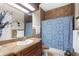 Well-lit bathroom features a sink, a toilet, a shower with a patterned curtain, and tiled walls at 103 Mecca St, Port Charlotte, FL 33954