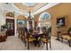 An expansive dining room with coffered ceilings, large window, elegant chandelier, and seating for ten at 103 Mecca St, Port Charlotte, FL 33954