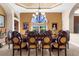 Formal dining room featuring coffered ceilings, large window, elegant chandelier, and seating for eight at 103 Mecca St, Port Charlotte, FL 33954