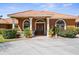 Charming home exterior featuring a terracotta tile roof, columned entryway, and meticulously landscaped front yard at 103 Mecca St, Port Charlotte, FL 33954