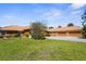 Expansive front lawn showcasing a home with a terracotta tile roof, three-car garage, and mature landscaping at 103 Mecca St, Port Charlotte, FL 33954