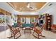 Spacious living room with tile flooring, a ceiling fan, and multiple rocking chairs set around a coffee table at 103 Mecca St, Port Charlotte, FL 33954