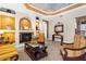 Elegant living room with a fireplace, coffered ceiling, archways, and comfortable seating at 103 Mecca St, Port Charlotte, FL 33954