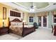 Spacious main bedroom featuring a trey ceiling, fan, tile flooring, and french doors to a patio at 103 Mecca St, Port Charlotte, FL 33954