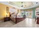 Bright main bedroom featuring a ceiling fan, decorative trey ceiling, and a glass door to the outside at 103 Mecca St, Port Charlotte, FL 33954