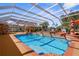 Beautiful screened-in pool area featuring ample decking, lush landscaping, and a tiki bar for ultimate relaxation at 103 Mecca St, Port Charlotte, FL 33954
