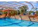 Stunning screened pool with a grotto-style waterfall, lush landscaping, and a tiki bar for ultimate outdoor enjoyment at 103 Mecca St, Port Charlotte, FL 33954