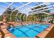 Stunning screened pool and lanai area with lush landscaping, outdoor seating, and sunbathing spots at 103 Mecca St, Port Charlotte, FL 33954