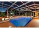 Tranquil night view of the screened-in pool area, showcasing serene waters, tasteful landscaping, and ambient lighting at 103 Mecca St, Port Charlotte, FL 33954