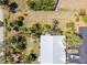 Aerial view shows the roof and surrounding yard, with trees and greenery at 107 Jose Gaspar Dr, Englewood, FL 34223