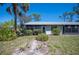 Backyard showing a screened patio, green lawn and lush surrounding landscape at 107 Jose Gaspar Dr, Englewood, FL 34223