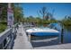 Dockside view of a white and blue boat on a canal, with a 'Manatee Area' caution sign nearby at 107 Jose Gaspar Dr, Englewood, FL 34223