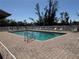 Refreshing community pool with clear water, surrounded by a brick patio and lounge chairs at 107 Jose Gaspar Dr, Englewood, FL 34223